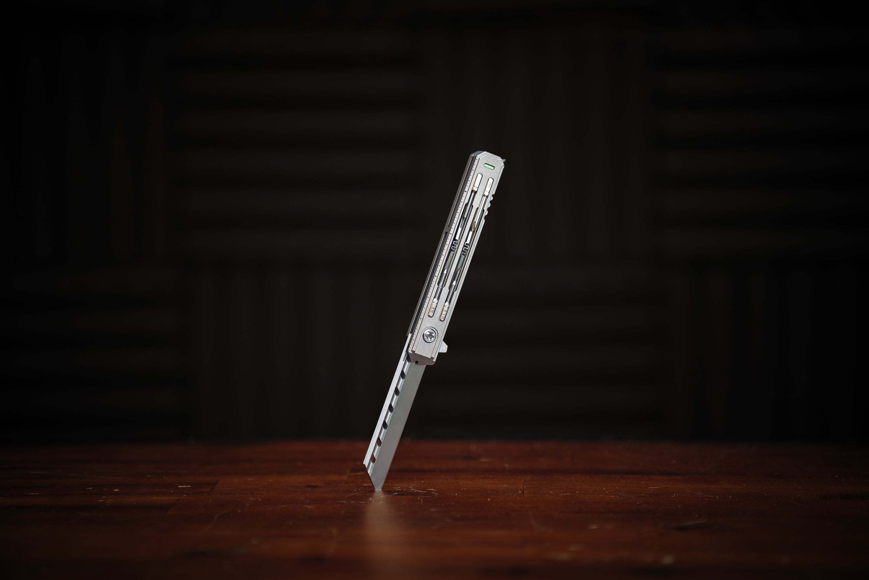 Knife blade on a wooden surface with a dark background