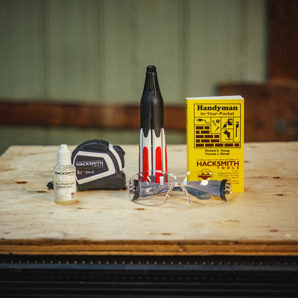 Hacksmith.store Lite Tool Bundle featuring various hand tools, including pliers, screwdrivers, and wrenches arranged on a wooden surface.