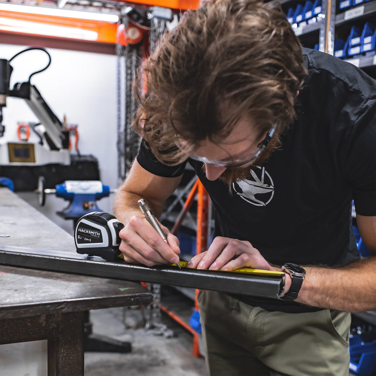 Hacksmith Tools measuring tape extended with clear measurement markings, compact tape measure for accurate length measurements.