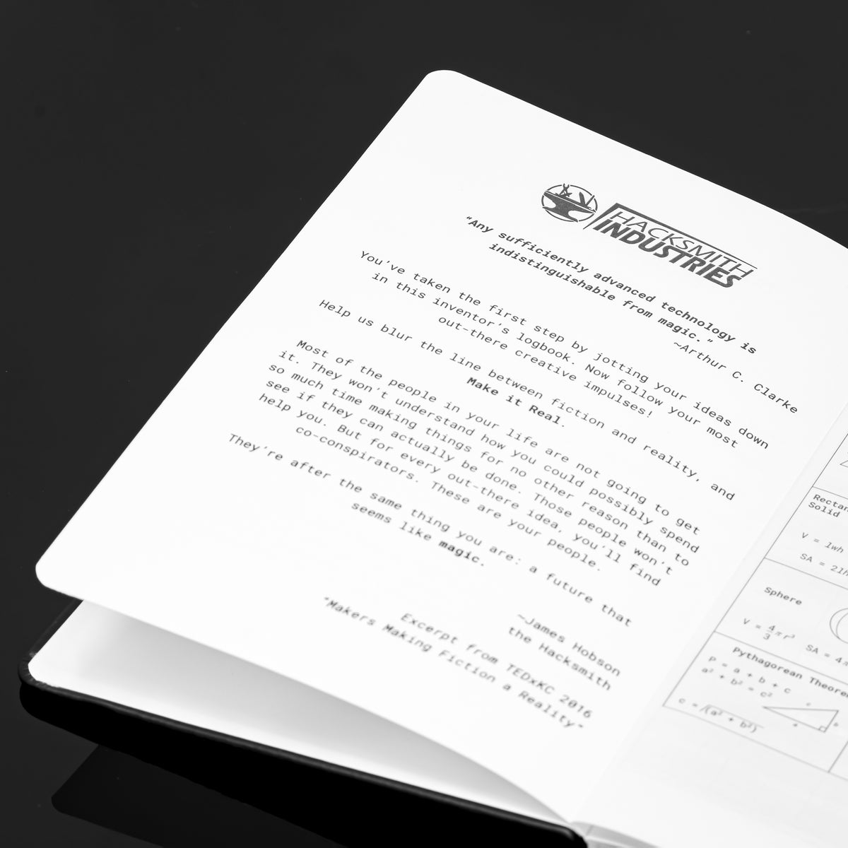 Black inventor's notebook by Engineered By Hacksmith with labeled pages and spiral binding, designed for creative engineering projects.